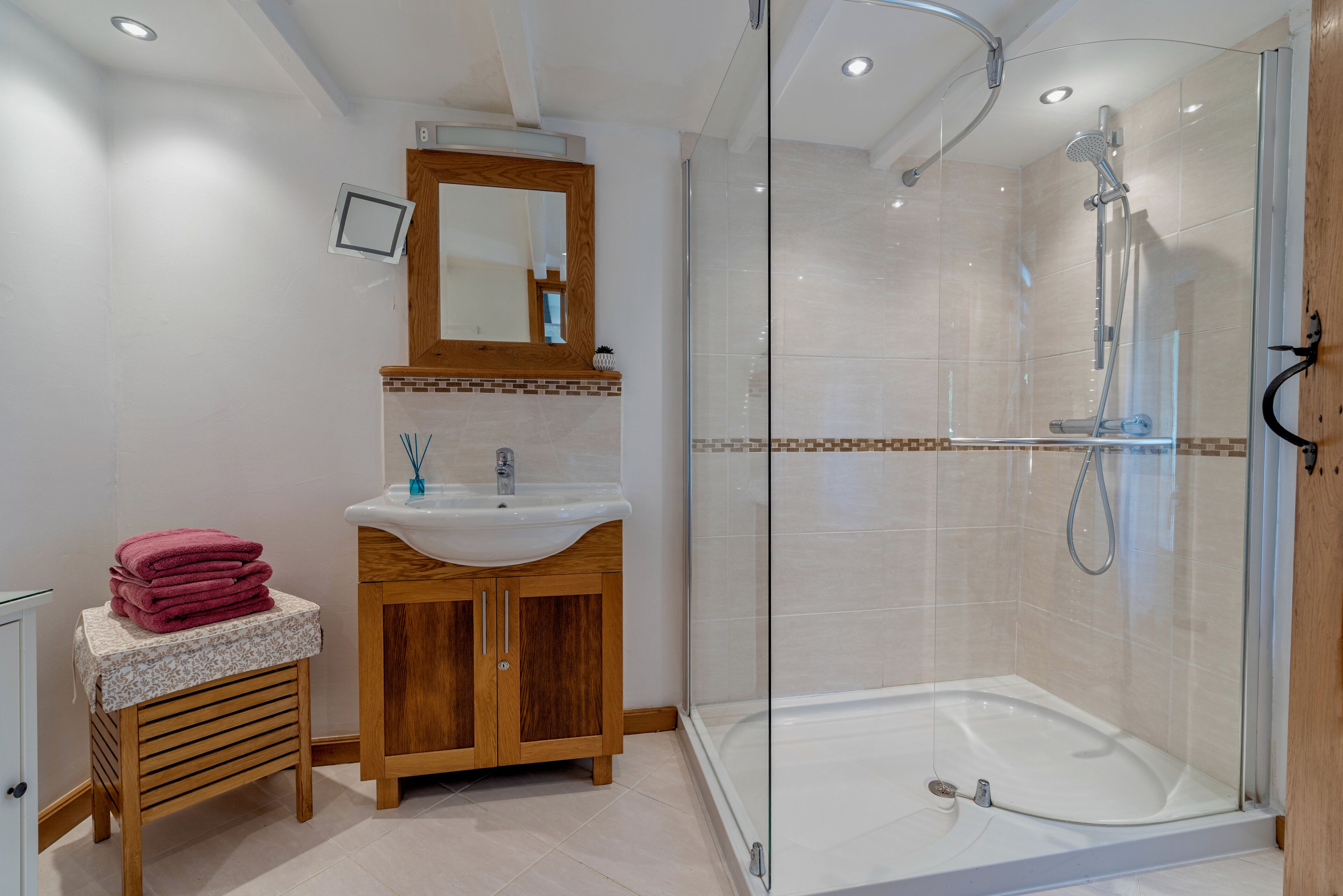 Une salle de bain moderne avec une douche à parois de verre, un meuble-lavabo et un miroir au-dessus.