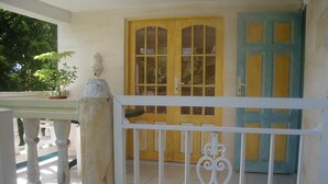 A white metal gate with a decorative design, a yellow door with glass panels, and a blue door with a geometric pattern. - Bottom of villa for rent in diamond (F3) (Diamant)
