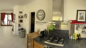 A spacious kitchen with a dining area, a large window, and a modern stove.