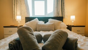 A neatly made bed with rolled towels, a pillow with "Love" written on it, and two bedside lamps. - Views Of The Clwydian Range, Nr Ruthin. Snowdonia 1hr. Local pub 1 mile (Rhewl)
