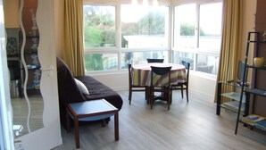 Une pièce comprenant une table à manger, des chaises, un canapé et une bibliothèque.