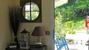 Une pièce avec un meuble noir, une lanterne en verre et une fenêtre donnant sur un jardin.