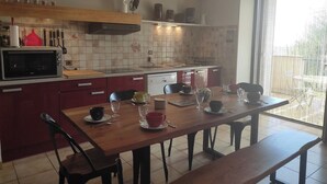 Una cocina moderna con una mesa de madera, sillas, un microondas y un ventanal con vistas.