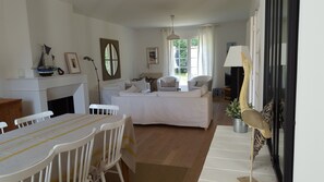 Ein gemütliches Wohnzimmer mit Kamin, einem Esstisch mit Stühlen, einer Couch und einem Fernseher.