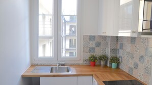 Eine Küche mit Holzausziehtisch, einer Spüle mit zwei Becken und einem fliesenverzierten Rücksprung.