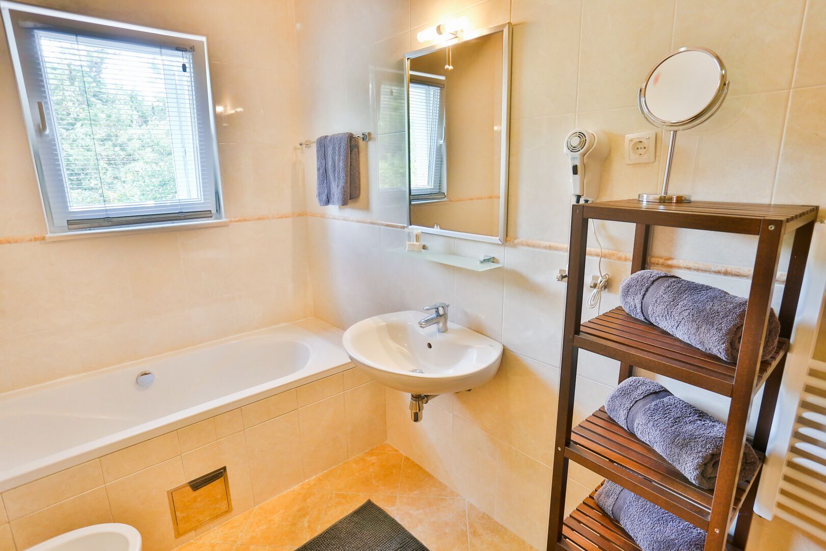 Une salle de bain avec une baignoire, un lavabo et un porte-serviettes.