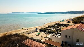 Un hotel sul lungomare con vista sulla spiaggia, posti a sedere all'aperto e una zona piscina.