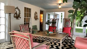 A room with a wooden table, wicker chairs, a patterned rug, and a view of the outdoors. - Miner Cottage-Historic Antique Home just steps from the Equinox Resort (Manchester)