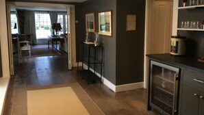 A spacious kitchen with a dining area, a hallway, and a door leading to another room. - Miner Cottage-Historic Antique Home just steps from the Equinox Resort (Manchester)