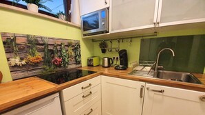 A kitchen with white cabinets, a wooden countertop, a built-in microwave, and a sink. - Stylish bright apartment, very conveniently. Metro just around the corner. Internet (München)