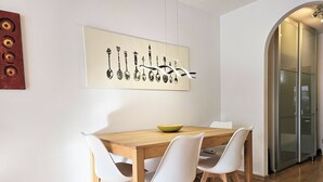 A dining area with a wooden table, white chairs, and a bowl. - Stylish bright apartment, very conveniently. Metro just around the corner. Internet (München)