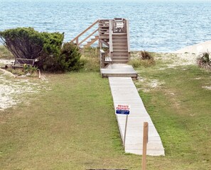 A wooden staircase leading to a private property by the beach.