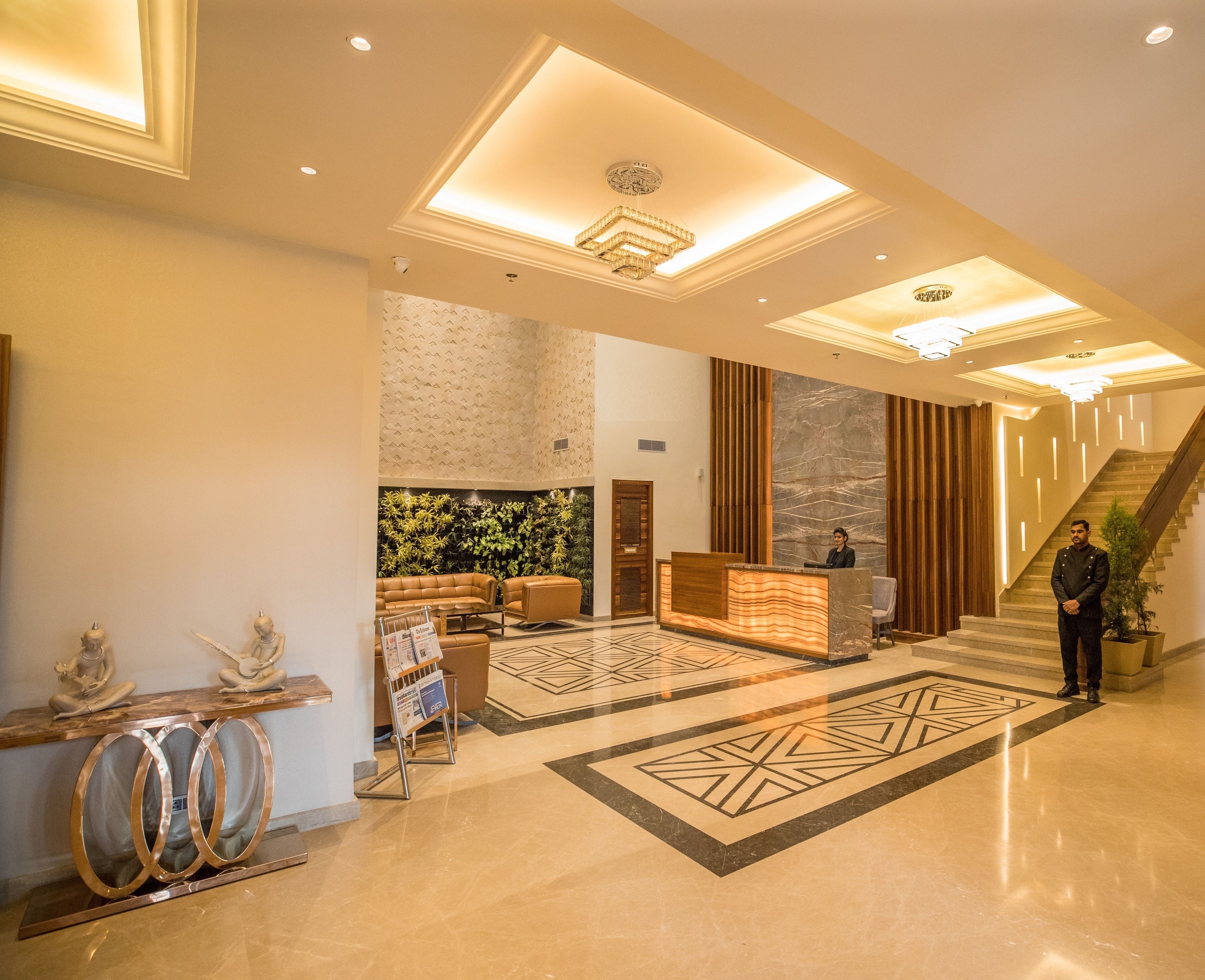 A spacious lobby with a reception desk, seating area, and a staircase.