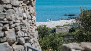 A stone wall, a beach, and a calm sea.