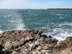 Une côte rocheuse où les vagues s'écrasent contre les rochers.