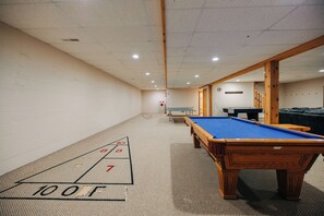 A room with a pool table, a shuffleboard table, and a billiards table. - Secluded, Private 5000 Square Foot Luxury Lodge Located On 20 Wooded Acres. (Cambridge)