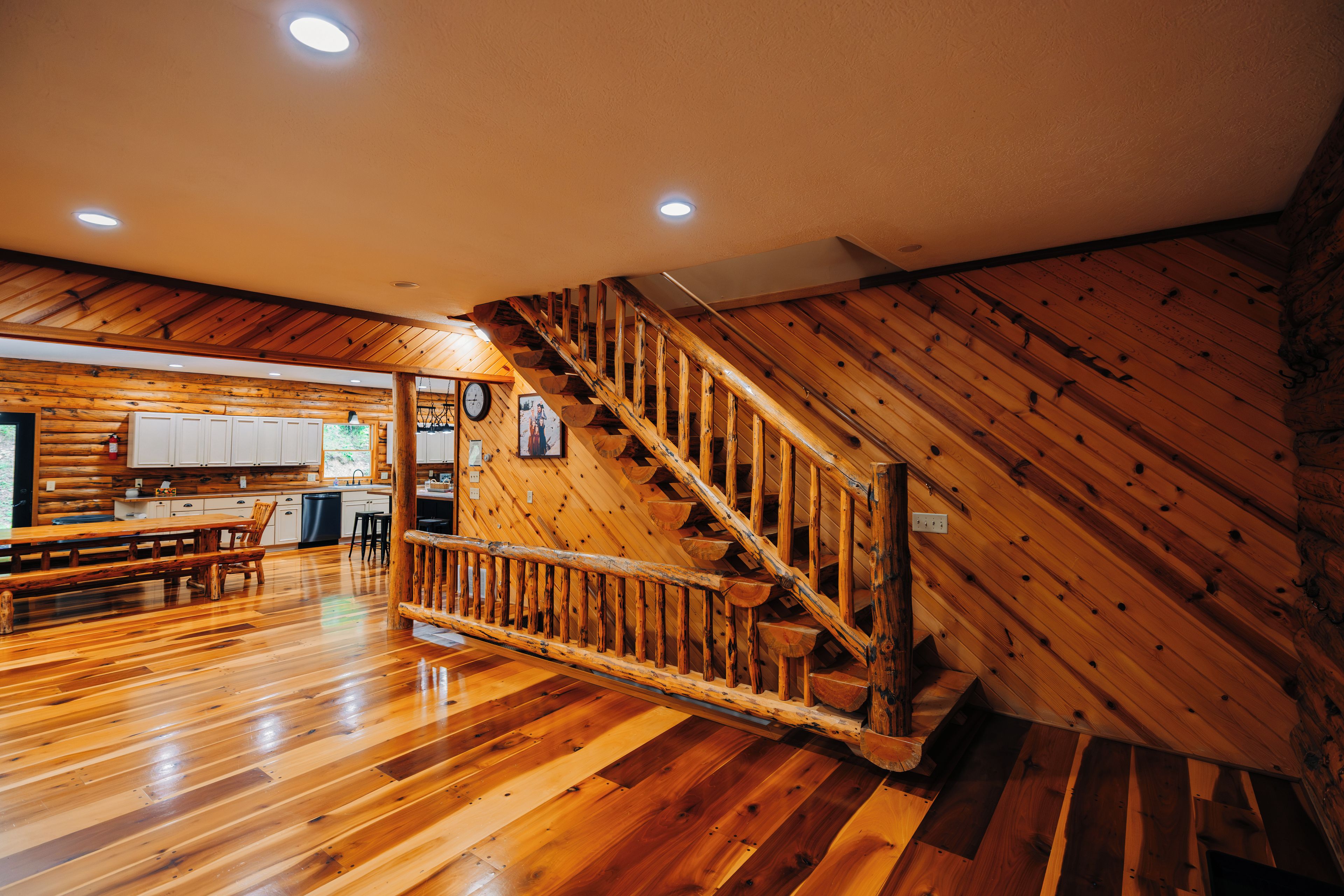 Un intérieur en bois avec un escalier, des planchers en bois et un coin cuisine.