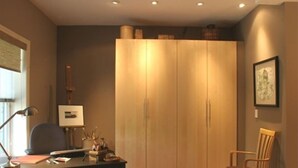 Une pièce comprenant un bureau, une chaise et une grande armoire.