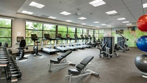 Et fitnesscenter med løbebånd, styrkemaskiner og vægte.