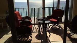 A balcony with wicker chairs and a table, overlooking a clear view of the ocean. - The Leeway,  Beautiful Gulf Front Condo on the Gulf of Mexico (Gulf Shores)