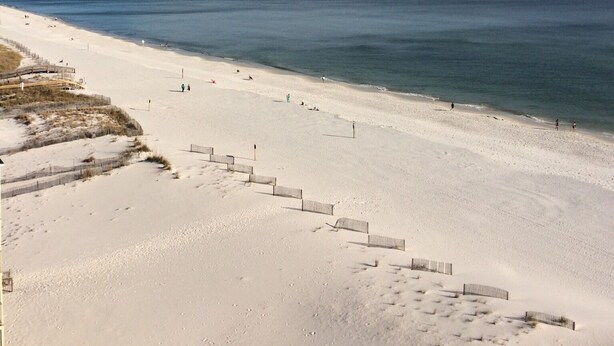 A beach with a sandy path leading to the water, a wooden walkway, and a clear sky. - The Leeway,  Beautiful Gulf Front Condo on the Gulf of Mexico (Gulf Shores)