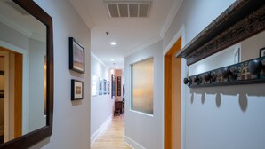A hallway with wooden flooring, framed artwork on the walls, and a decorative wooden panel on the right. - Very Special Downtown Asheville Loft  (Asheville)