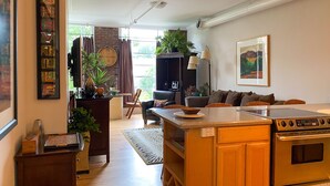 A modern kitchen with a central island, wooden cabinets, and a built-in oven. - Very Special Downtown Asheville Loft  (Asheville)