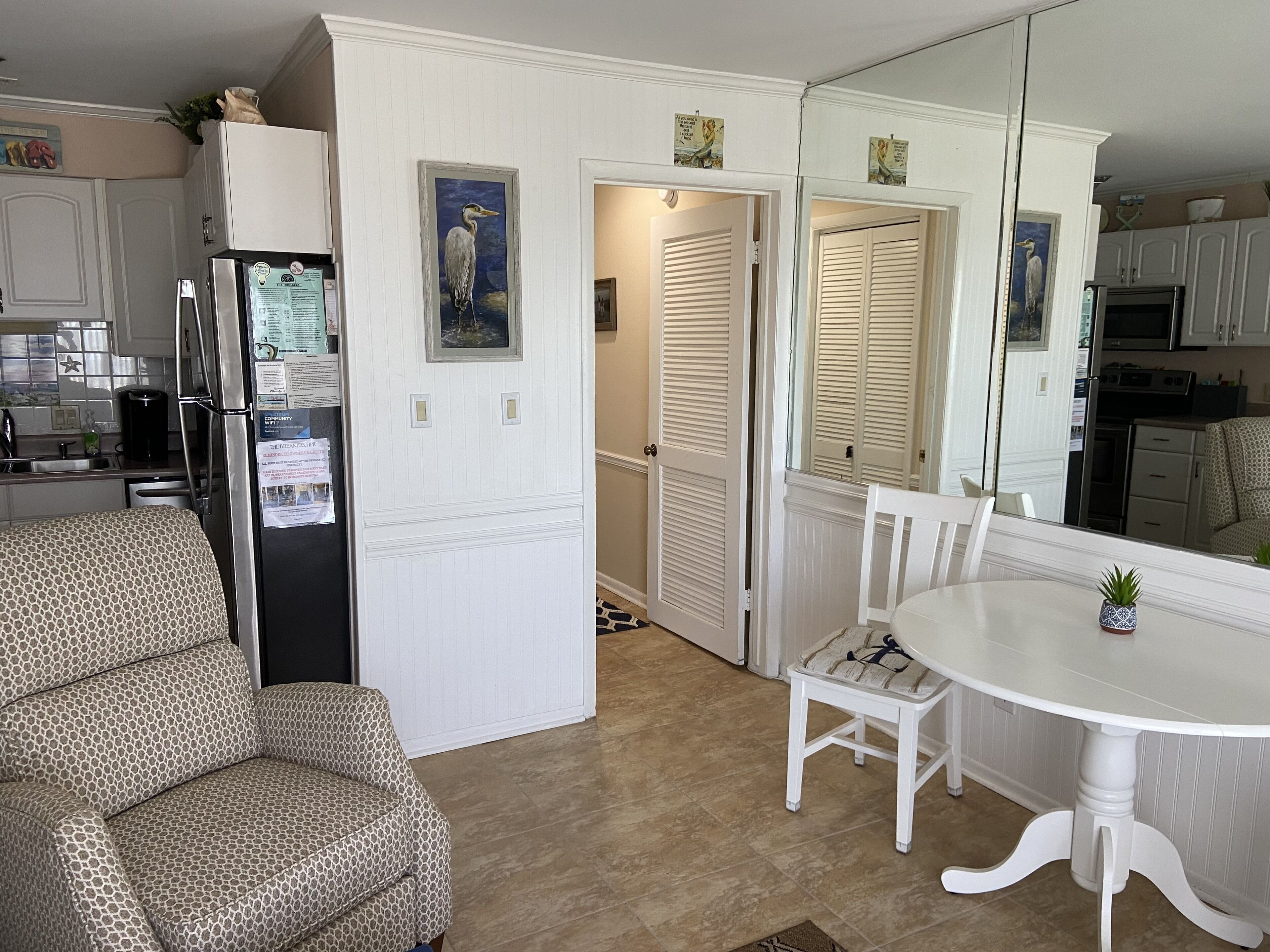 A compact kitchen with a refrigerator, microwave, and stove. There is a dining area with a table and chairs.