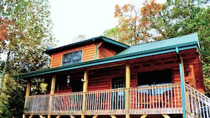 A two-story log cabin with a balcony and a porch. - Deer Country Vacation Cabins #3 - Long Range View, Dogs Friendly (Waynesville)