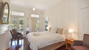 Una camera da letto con un letto grande, una sedia, un comodino e uno specchio.