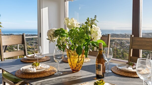 Une table dressée pour le dîner, avec vue sur la ville et l’océan.