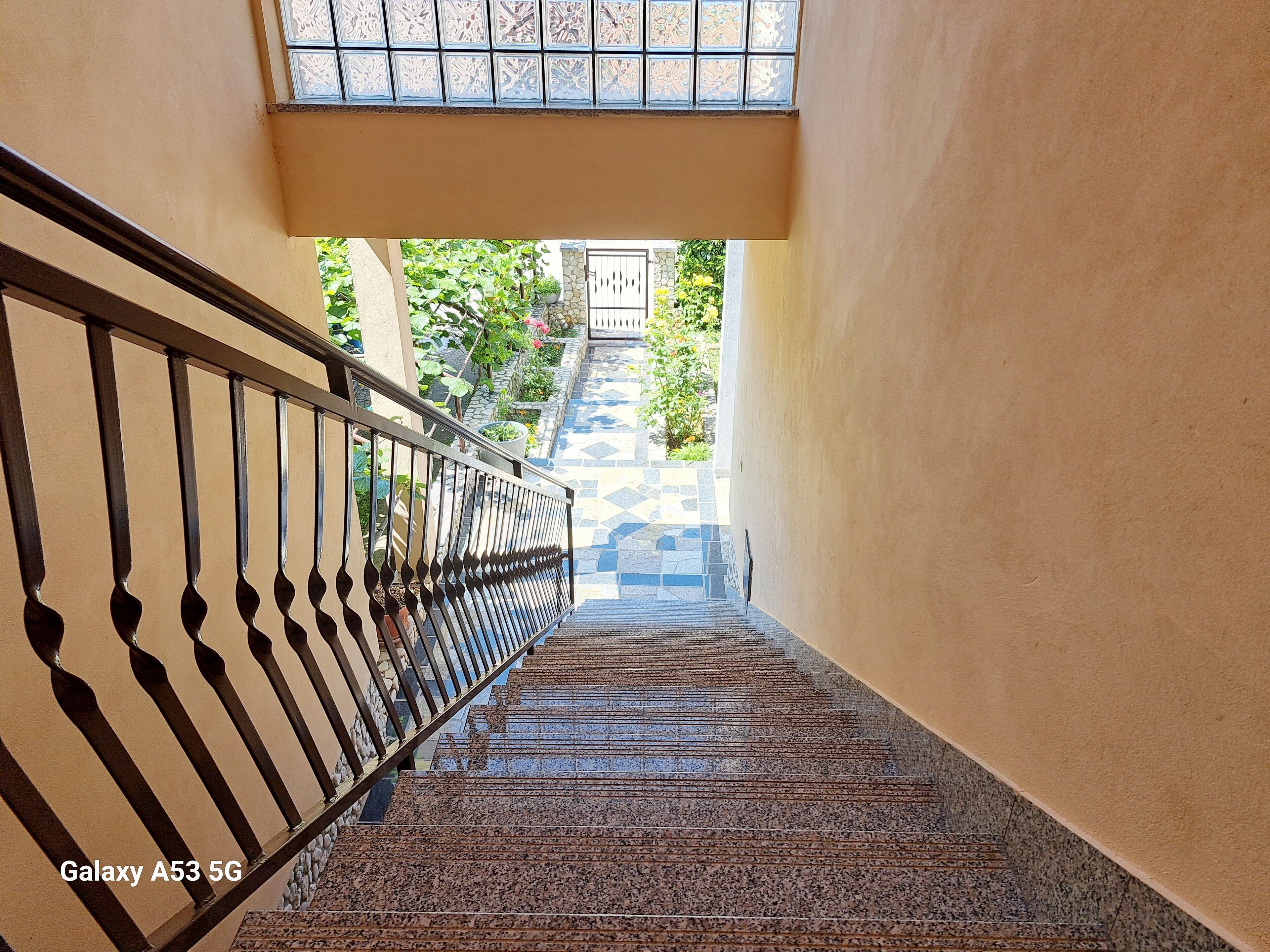Eine Treppe mit Metallgeländer führt zu einem verschlossenen Eingang.