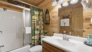A wooden cabin bathroom with a bathtub, toilet, and sink.