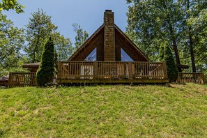 A wooden cabin with a balcony, surrounded by trees. - Premium Rustic Cabin Perfect Getaway, Private Hot Tub,Piano, Near Shows & Big Cedar, Jacuzzi Tub! (Ridgedale)