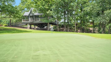 A golf course with a house in the background.