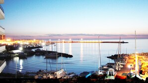 A marina with boats docked, a bridge in the background, and a cityscape with lights. - Seafront apartment. 3 double beds and 3 bathrooms (Gallipoli)