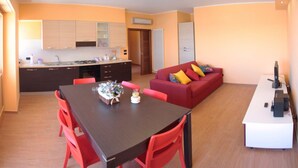 A compact living space with a dining area, a kitchenette, and a sofa. - Seafront apartment. 3 double beds and 3 bathrooms (Gallipoli)