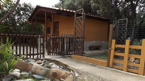 Un edificio rústico con una valla de madera, una entrada portonada y un camino de piedra que lo conduce.
