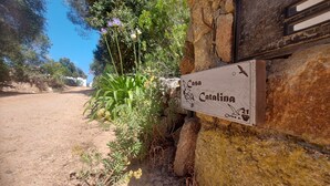 En rustik stenmur med en skylt som visar ”Casa Catalina” och numret ”21”.