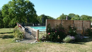 A backyard with a wooden deck, a swimming pool, and a wooden fence. - Walnut Lodge, charming holiday Gite in central rural France (Pleumartin)