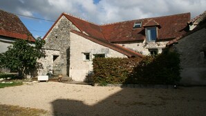 A stone building with a red-tiled roof, a small window, and a door. - Walnut Lodge, charming holiday Gite in central rural France (Pleumartin)