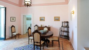 A dining area with a round table, chairs, and a patterned rug. - ATRANI "CASA ROSSA" AMALFI COAST WITH SEA VIEW (ATRANI)