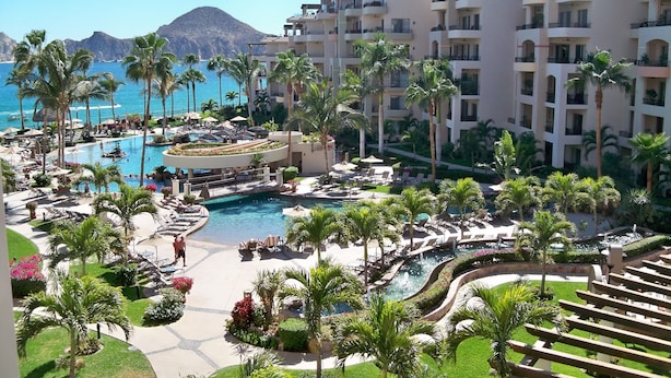 A resort with a central pool, palm trees, and a view of the sea. - Stunning Villa at Villa La Estancia, Directly on Medano Bay- Beautiful Views (Cabo San Lucas)