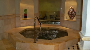 A hot tub with a glass enclosure, surrounded by stone walls and two small alcoves with decorative vases. - Stunning Villa at Villa La Estancia, Directly on Medano Bay- Beautiful Views (Cabo San Lucas)
