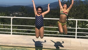 Two people jumping into a pool with a scenic view of mountains in the background. - Stylish accommodation with stunning views, private pool, vineyard (Penela, Coimbra)