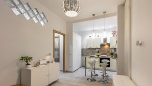 A modern kitchen with a central island, bar stools, and pendant lighting.