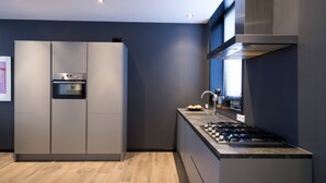 A modern kitchen with a built-in oven, a gas stove, and a stainless steel range hood. - Villa Antonius Amsterdam (Ouderkerk aan de Amstel)
