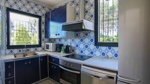 A compact kitchen with a microwave, stove, and sink. - Club Villamar - Charming villa in peaceful surroundings with private pool and fabulous sea views (Tamariu)
