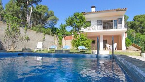 A two-story house with a swimming pool, outdoor furniture, and a stone wall. - Club Villamar - Charming villa in peaceful surroundings with private pool and fabulous sea views (Tamariu)