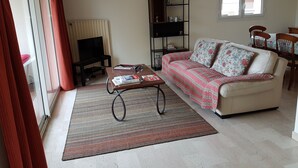 A living room with a sofa, coffee table, bookshelf, and a fireplace. - 4-room apartment 90 m² + Terrace. Sleeps 5 Immediate proximity to beaches (Bandol)